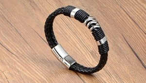Détail du bracelet en cuir tressé noir avec fermoir magnétique et anneaux argentés