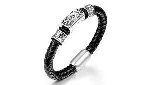 Detail of men's braided leather bracelet with vintage pattern metal charms and magnetic clasp