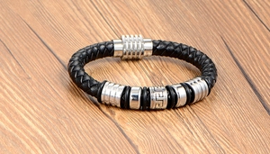 Detail of men's black leather braided bracelet with Greek key pattern metal bead