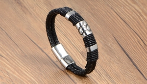 Détail d'un bracelet en cuir tressé pour homme avec perle en acier à motif patte de chat