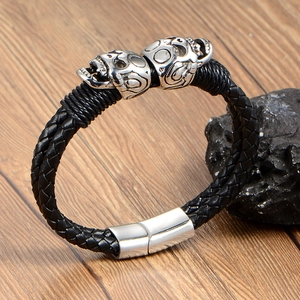 Men's punk braided leather bracelet featuring dual silver skull charms and magnetic clasp