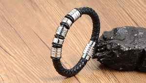 Detail of black woven leather bracelet with silver geometric metal beads and magnetic clasp