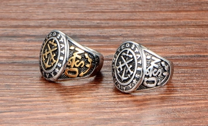Macro shot of silver and gold United States Navy military rings on wooden surface
