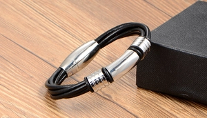 Detail of multi-layer black braided leather bracelet with silver magnetic steel clasp