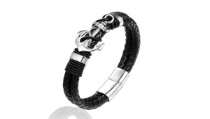 Detail of woven black leather bracelet featuring a polished silver metal anchor and magnetic clasp