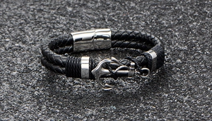 Detail of nautical braided black leather bracelet with silver anchor and magnetic clasp