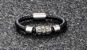 Gros plan du bracelet en cuir tressé noir avec tête de mort argentée et fermoir magnétique