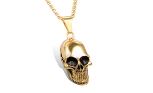 Gros plan du pendentif crâne en acier inoxydable doré avec textures punk vintage