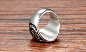 Macro view of vintage stainless steel ring with embossed Fu character and oxidized finish