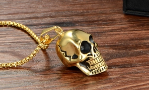 Détail macro du pendentif crâne gothique doré avec accents noirs antiques et chaîne à mailles carrées