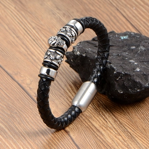 Men's vintage black woven leather punk bracelet with silver skull charms and magnetic clasp