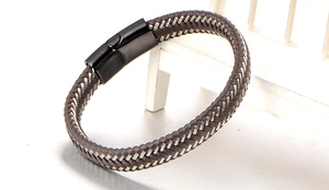 Detailed view of brown braided leather bracelet texture with black matte metal magnetic clasp