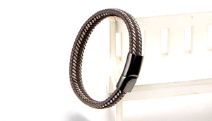 Close-up of braided dark brown leather cord with silver thread and magnetic clasp