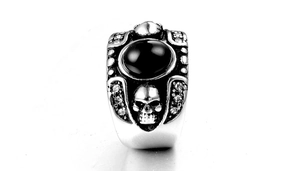 Détail du relief de crâne et de la pierre noire sur une bague punk en acier au titane