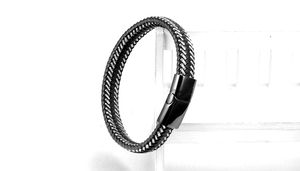 Detail of woven leather cord texture and glossy black metal clasp on minimalist bracelet