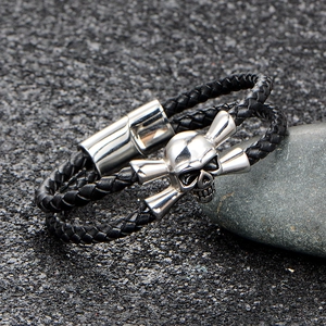 Punk black woven leather bracelet featuring a silver polished skull and crossbones charm