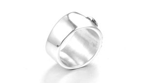 Gros plan d'une bague punk large avec pierre noire et détails gravés en métal argenté