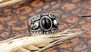 Vue macro de la bague crâne vintage avec pierre noire ovale et détails en acier inox