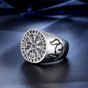 Vintage stainless steel Viking compass ring with Runic engravings on a blue background