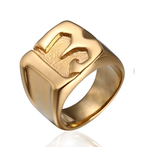 Détail d'une bague punk dorée avec le chiffre 13 gravé sur une surface carrée plane