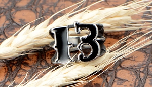 Macro view of vintage stainless steel punk ring featuring lucky number 13 on leather