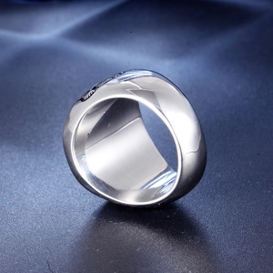 Macro shot of silver titanium ring featuring detailed eagle wing carvings and polished edges