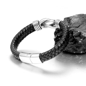 Dettaglio del bracciale in pelle intrecciata nera con nodo infinito e chiusura magnetica