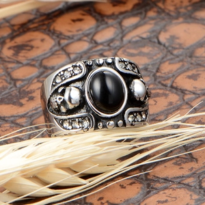 Bague gothique rétro avec pierre onyx noire, crâne et strass sur fond de cuir brun