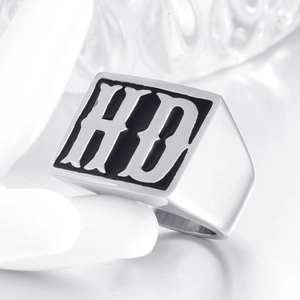 Close-up of silver titanium steel ring with HD embossed lettering on rectangular face