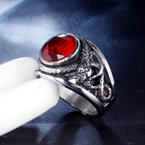 Macro shot of vintage titanium steel ring featuring an oval red gemstone and dragon scale textures