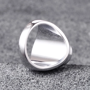 Macro shot of wide silver stainless steel men's ring with polished mirror finish on stone