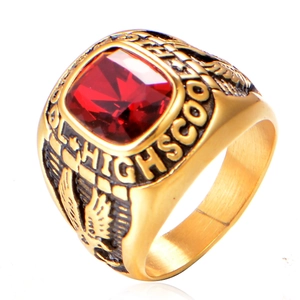 Detail view of gold high school ring with red square gemstone and eagle engraving