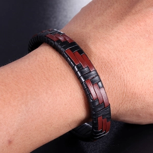 Gros plan sur un bracelet tressé pour homme en cuir noir et brun-rouge avec acier titane