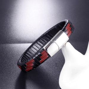 Gros plan d'un bracelet pour homme en cuir tressé noir et rouge avec un fermoir en métal argenté
