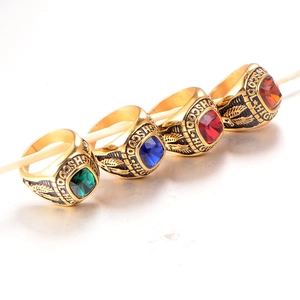 Detailed macro view of four men's vintage high school rings with colorful gemstones