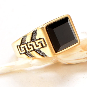 Detail of gold signet ring with black stone inlay and Greek meander pattern sides