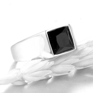 Macro shot of silver titanium steel signet ring with a large square black onyx gemstone