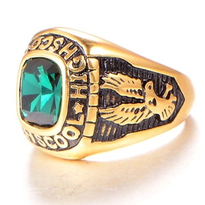 Macro shot of gold-finished high school class ring with emerald stone and eagle relief