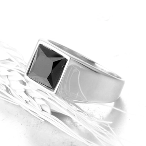 Detailed view of men's square black gemstone ring with silver metal band and minimal design