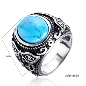 Macro detail of men's vintage steel ring with blue stone and floral engraving