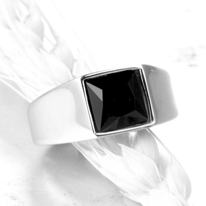 Macro shot of men's silver steel ring with a large square faceted black gemstone