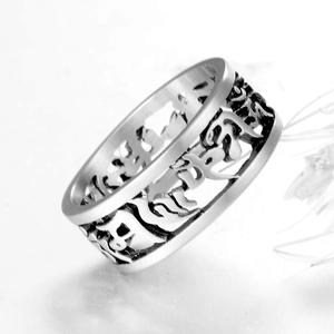 Detail of vintage silver titanium steel ring featuring hollowed Six-Syllable Mantra carvings