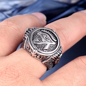 Makroaufnahme von Retro-Edelstahlring mit Horusauge am Finger des Modells