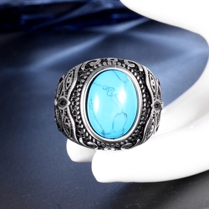 Detailed shot of vintage stainless steel ring with blue stone on white hand model
