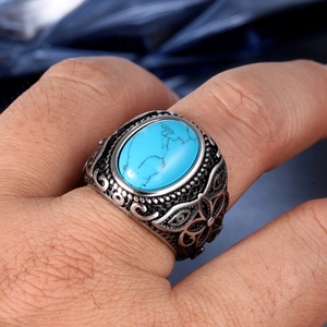 Detailed close-up of vintage engraved silver ring with an oval turquoise gemstone