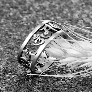 Macro shot of vintage titanium steel ring with Sanskrit mantra and hollow engraving