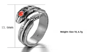 Détail d'une bague plume vintage en acier avec une pierre précieuse rouge polie