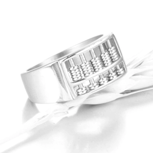 Macro view of silver abacus ring with miniature beads on a white feather background