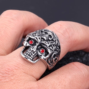 Macro shot of a punk skull ring in vintage silver with red crystal eyes and ornate relief