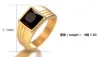 Macro detail of men's gold square ring featuring black gemstone and side textures